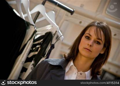 Brunette beside clothes rail