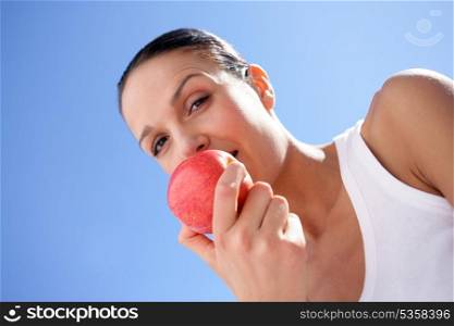 Brunette biting into red apple