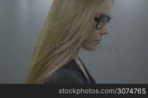 brunette business woman in elevator pressing button