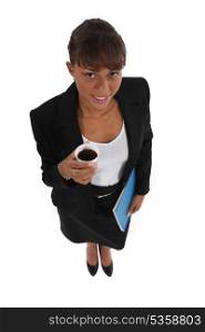 Brunette businesswoman holding folder and cup of coffee
