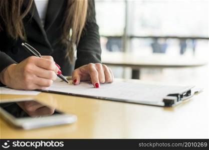 brunette businesswoman writing document