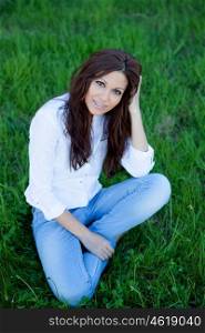 Brunette cool girl with brackets sitting on the grass