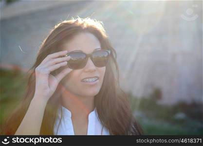Brunette cool girl with sunglasses in the park