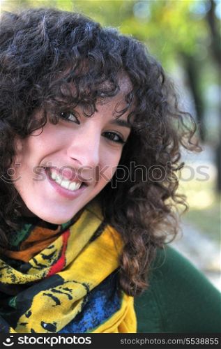 brunette Cute young woman with colorful scarf smiling outdoors in nature&#xA;