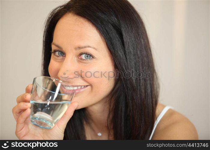Brunette drinking a glass of water