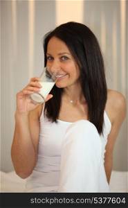 Brunette drinking glass of milk