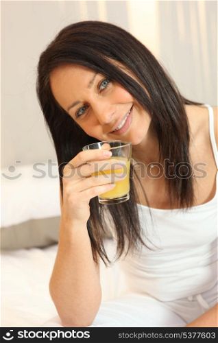 Brunette drinking orange juice in the morning