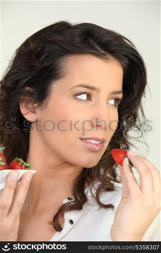 Brunette eating strawberries