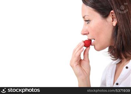 Brunette eating strawberry
