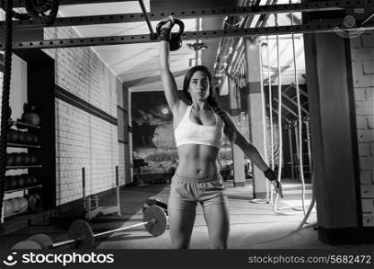 brunette girl at gym lifting a kettlebell weightlifting workout