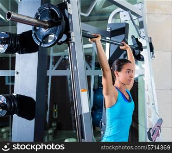 brunette girl in multipower barbell shoulder press Smith machine at gym