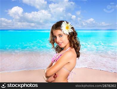 Brunette girl in tropical beach with daisy flower happy for vacation