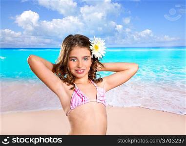 Brunette girl in tropical beach with daisy flower happy for vacation