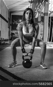 brunette girl kettlebell swing weightlifting workout exercise at gym