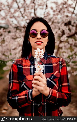 Brunette girl near a almond tree with many flowers