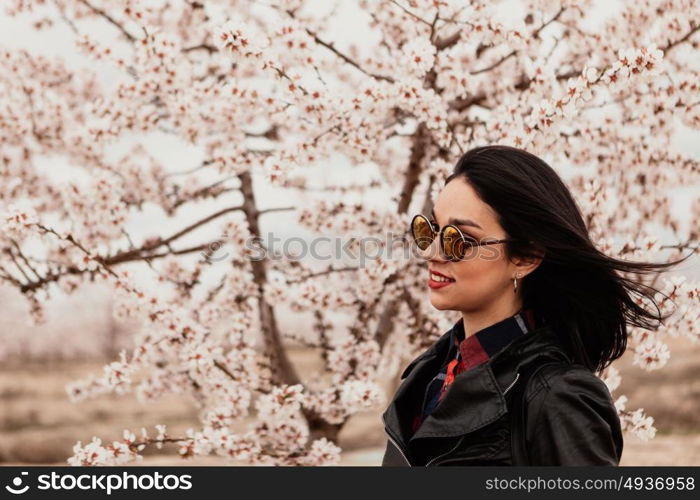 Brunette girl near a almond tree with many flowers