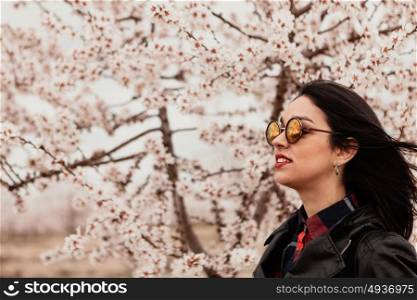 Brunette girl near a almond tree with many flowers