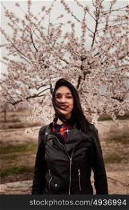 Brunette girl near a almond tree with many flowers