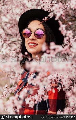 Brunette girl near a almond tree with many flowers