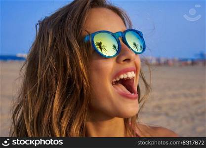 Brunette girl on beach sunglasses with palm tree reflection