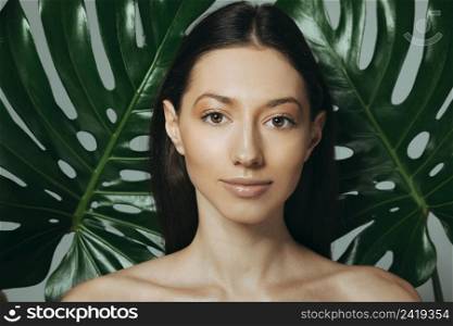 brunette girl posing with exotic leaves