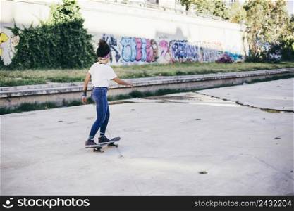 brunette girl riding skateboard street