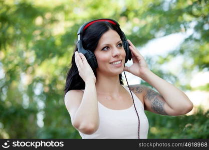 Brunette girl with headphones walking on a park