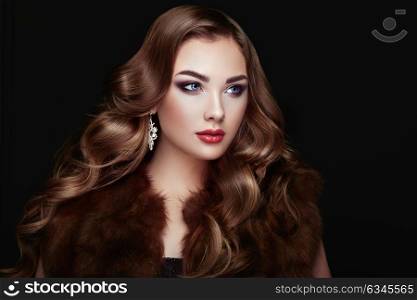 Brunette Girl with Long and shiny Curly Hair. Beautiful Model Woman in the Fur Coat Care and Beauty Hair products. Perfect Make-Up and Jewelry