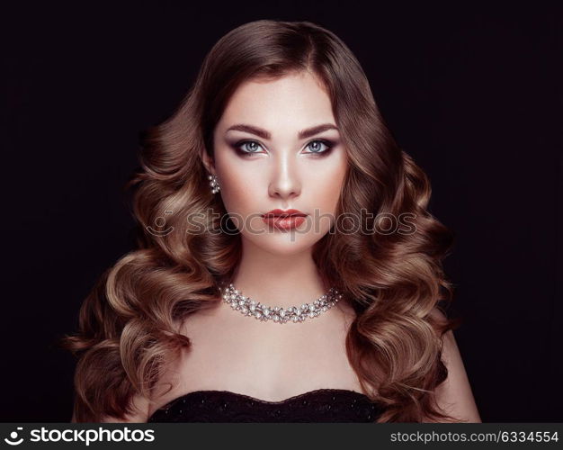 Brunette Girl with Long and shiny Curly Hair. Beautiful Model Woman with Curly Hairstyle. Care and Beauty Hair products. Perfect Make-Up and Jewelry