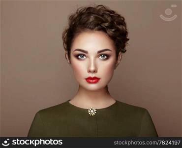 Brunette Girl with Long Healthy and Shiny Curly Hair. Care and Beauty. Beautiful Model Woman with Wavy Hairstyle. Make-Up and dark Green Dress