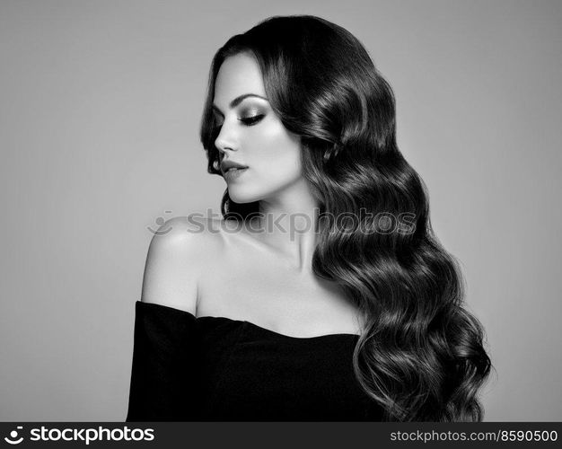 Brunette Girl with Long Healthy and Shiny Curly Hair. Care and Beauty. Beautiful Model Woman with Wavy Hairstyle. Black and white photo