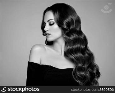 Brunette Girl with Long Healthy and Shiny Curly Hair. Care and Beauty. Beautiful Model Woman with Wavy Hairstyle. Black and white photo
