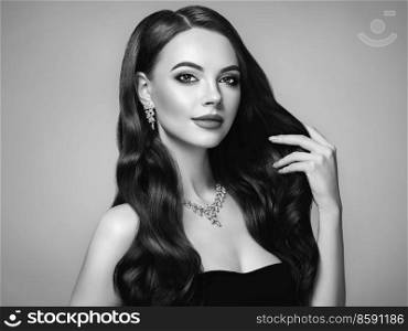 Brunette Girl with Long Healthy and Shiny Curly Hair. Care and Beauty. Beautiful Model Woman with Wavy Hairstyle. Black and white photo