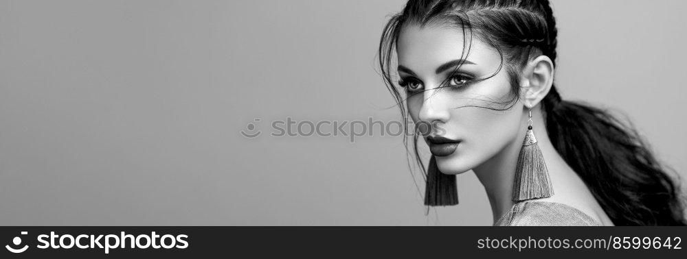 Brunette girl with perfect makeup. Beautiful model woman with curly hairstyle. Care and beauty hair products. Lady with braided hair. Model with jewelry. Black and White photo