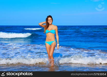 Brunette happy girl walking in the beach shore in summer vacation