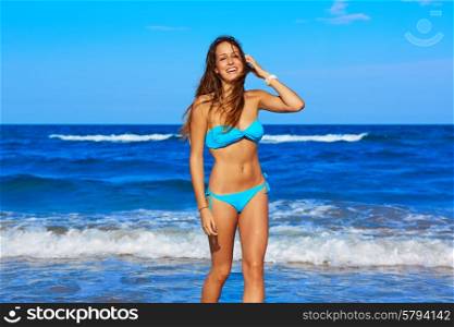 Brunette happy girl walking in the beach shore in summer vacation