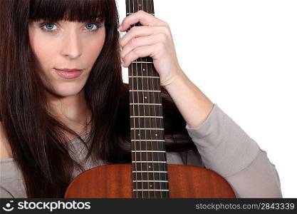 Brunette holding acoustic guitar