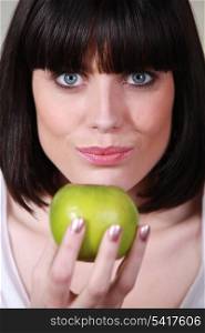 Brunette holding green apple