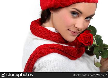 Brunette holding rose to face