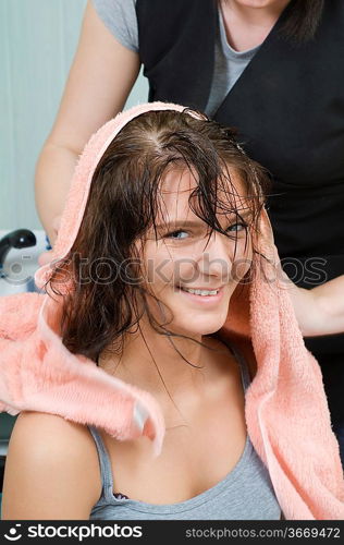 brunette in salon hair getting her hair dryied with a towel