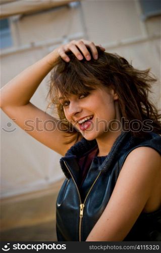 Brunette in sleeveless top playing with her hair