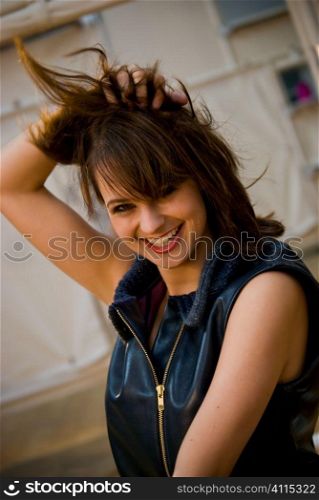 Brunette in sleeveless top playing with her hair
