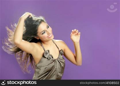 Brunette indian beautiful woman dancing at studio on purple background