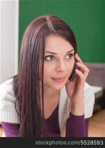 brunette indoor calling by cell phone and looking away