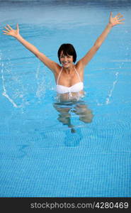 Brunette jumping in swimming pool