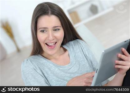 Brunette laughing at something on her tablet