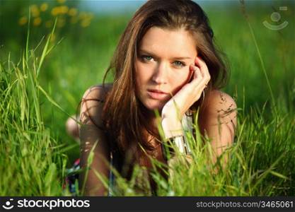 brunette lays on green grass