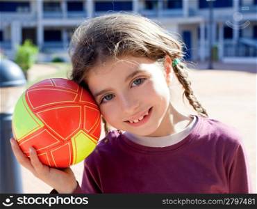 brunette little girl football player and ball smiling with blue eyes