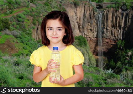 Brunette little girl with a water bottle with a waterfall of background