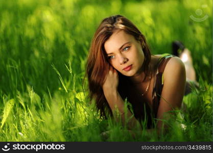 brunette lying on green grass